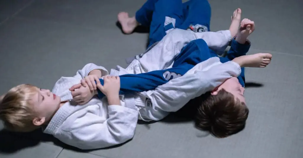 Kids practicing Brazilian jiu jitsu on mats, demonstrating a grappling technique