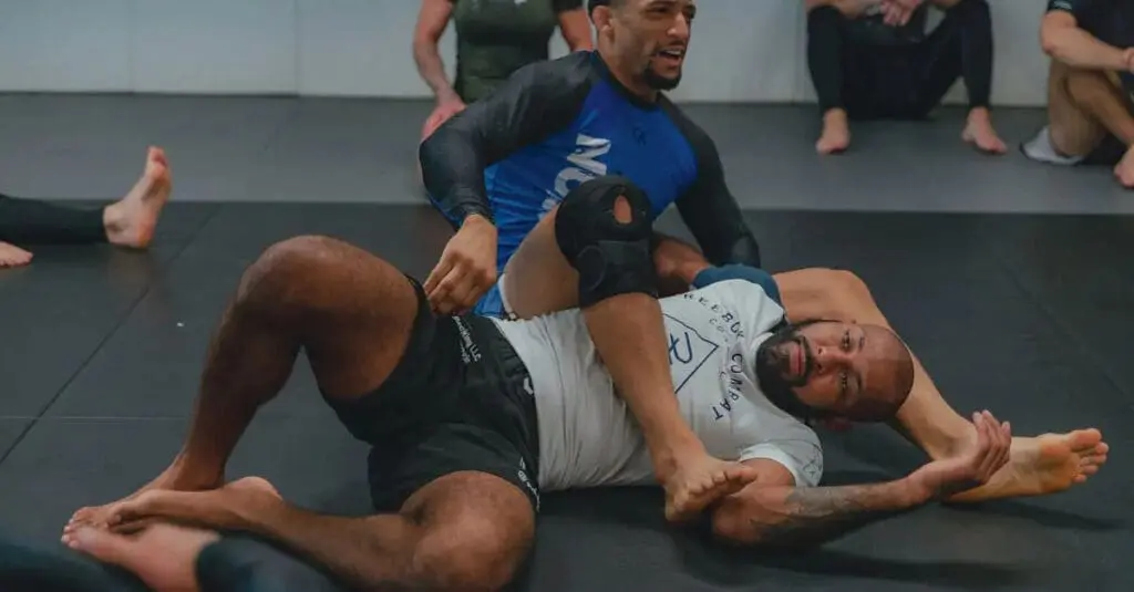 Two Brazilian Jiu Jitsu students sparring and practicing submission attempts, enhancing their understanding of BJJ for beginners positions.